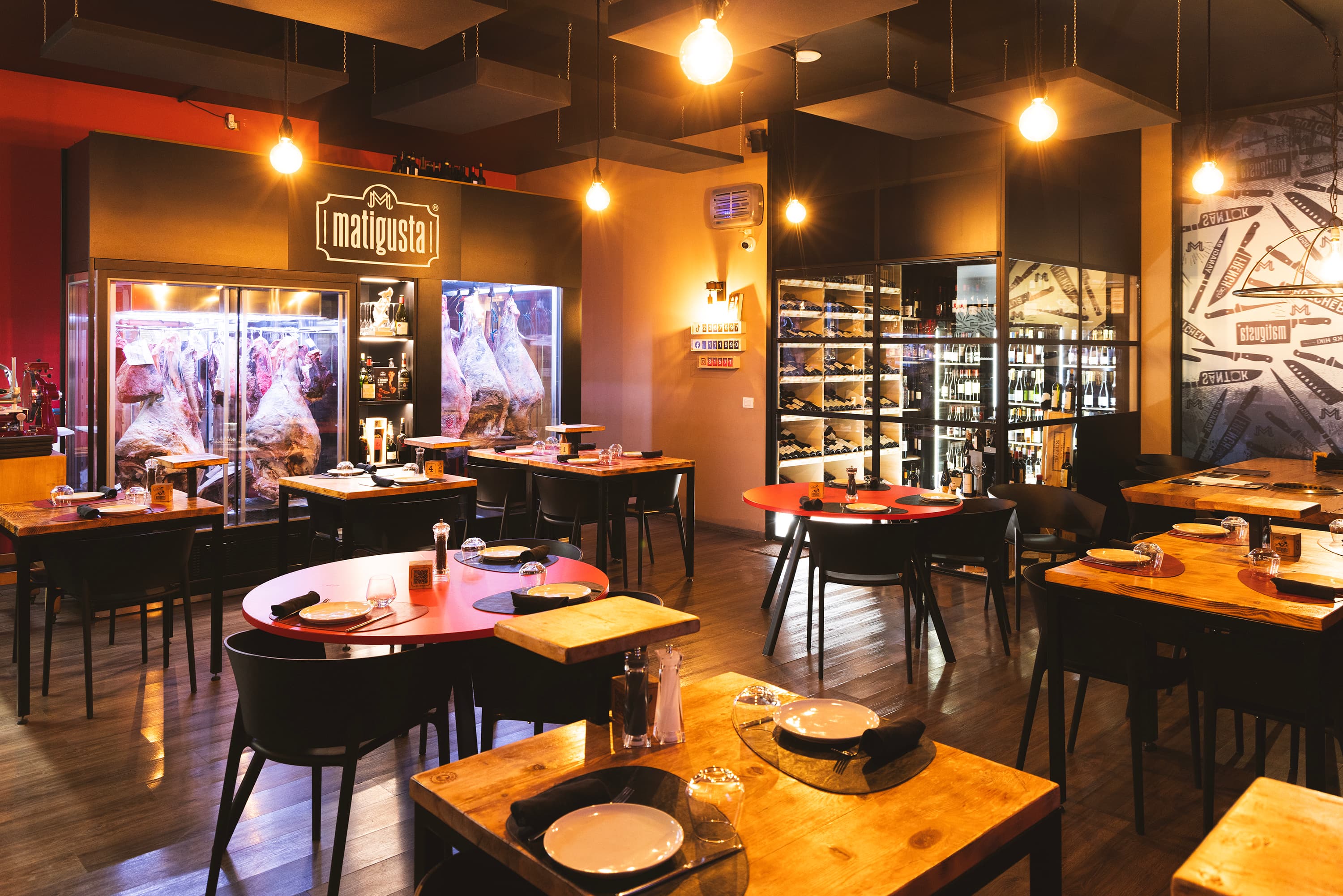 La sala del ristorante Matigusta con i frigoriferi di frollatura e i tavoli apparecchiati