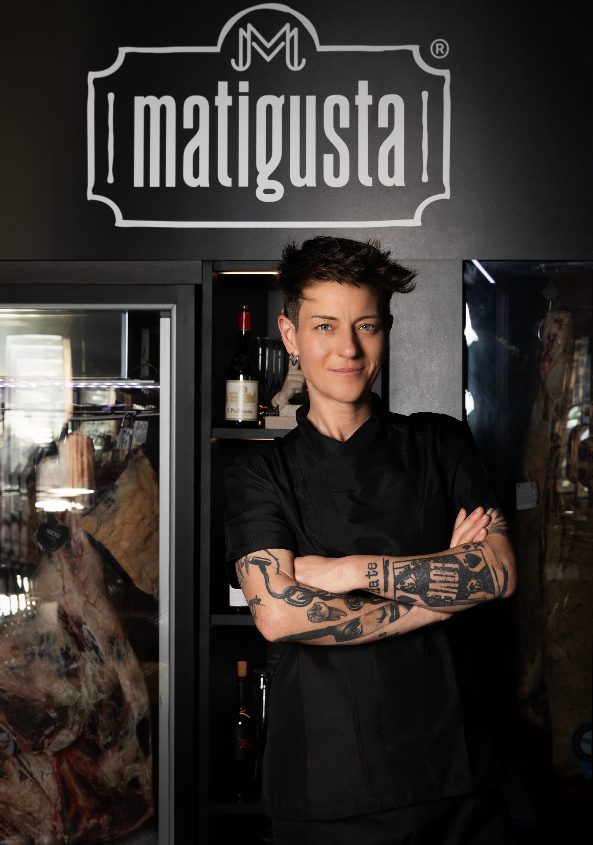 Ritratto di Matilde Tidei, titolare di Matigusta, davanti al logo del ristorante